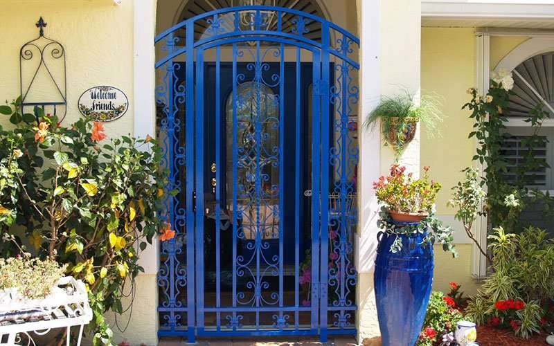 A blue door with wrought iron and glass.