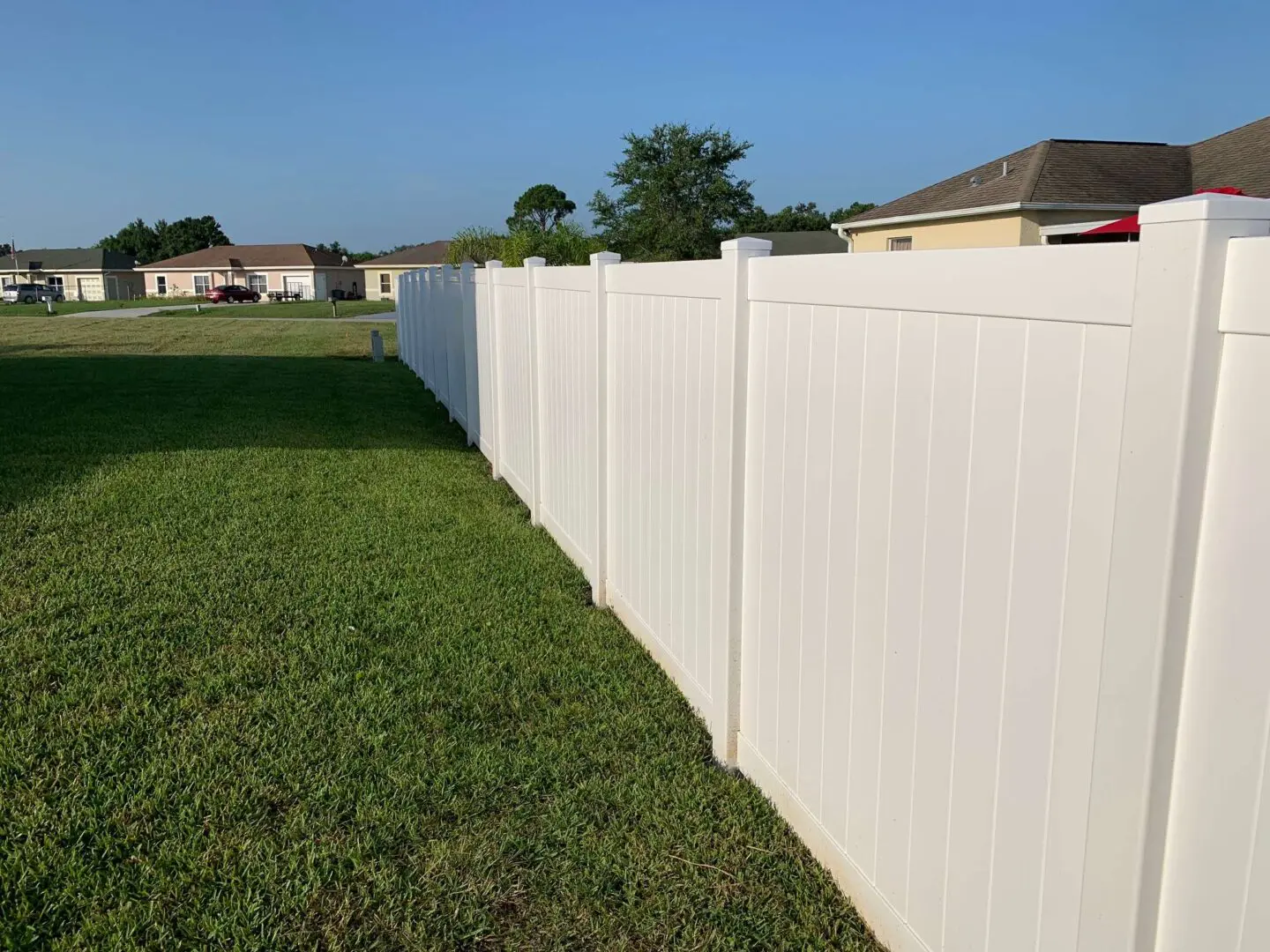 A white fence with grass in the foreground