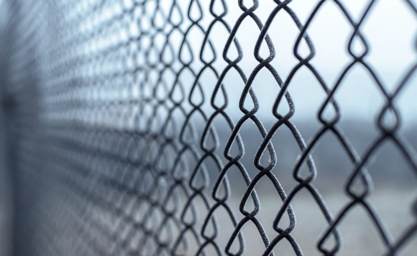 A chain link fence with a sky background