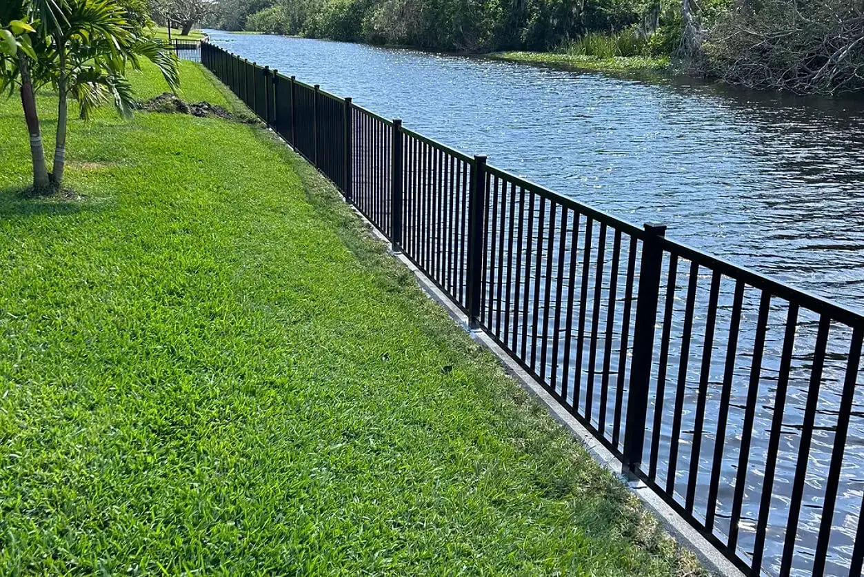 A fence that is next to the water.