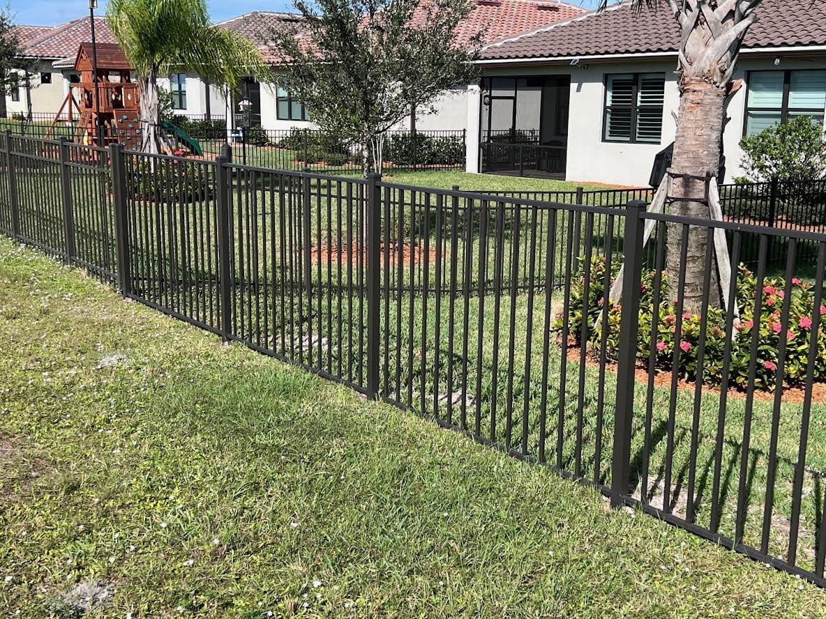 Black metal fence in front of a house.