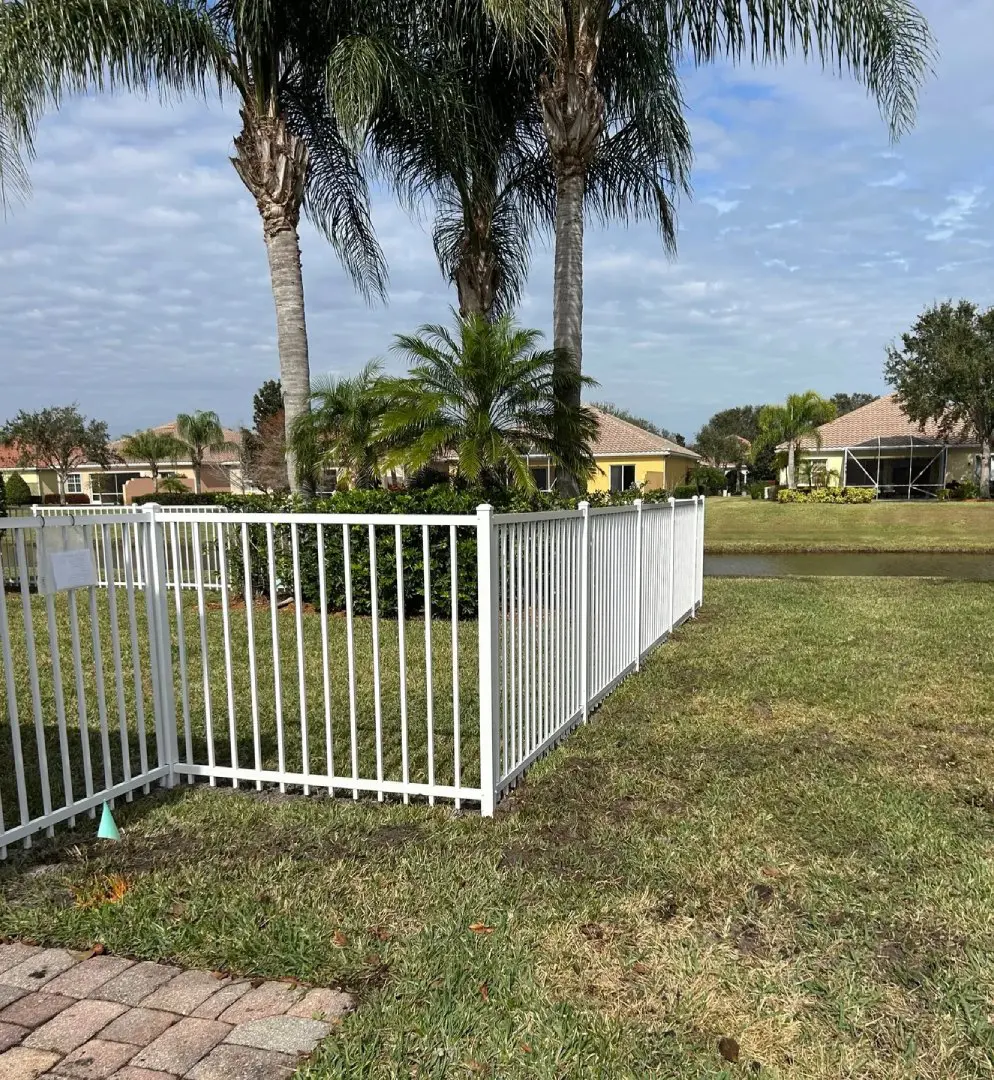 A white fence in the middle of a yard.