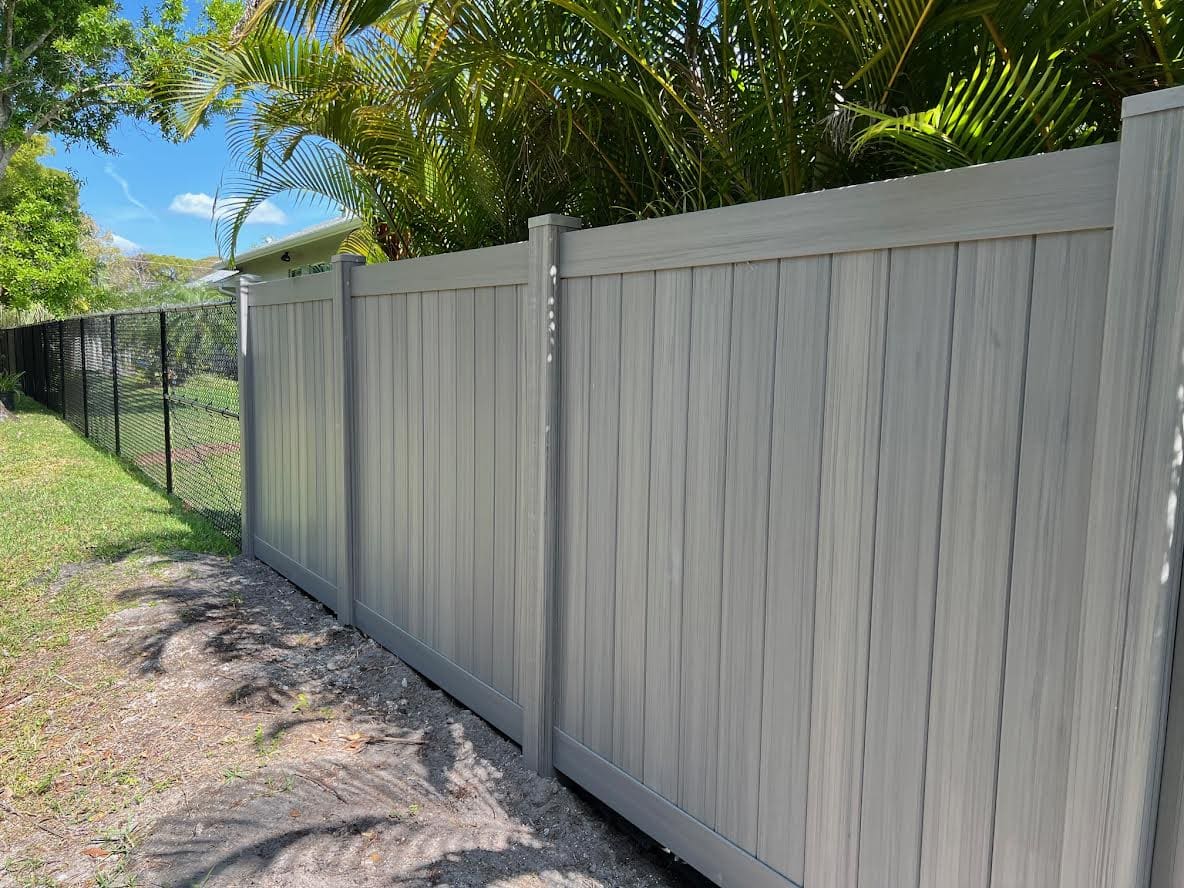 Gray vinyl fence with privacy slats.