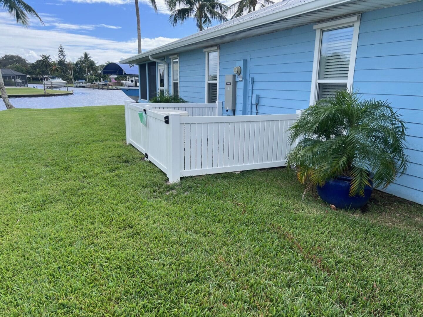 White fence next to blue house.