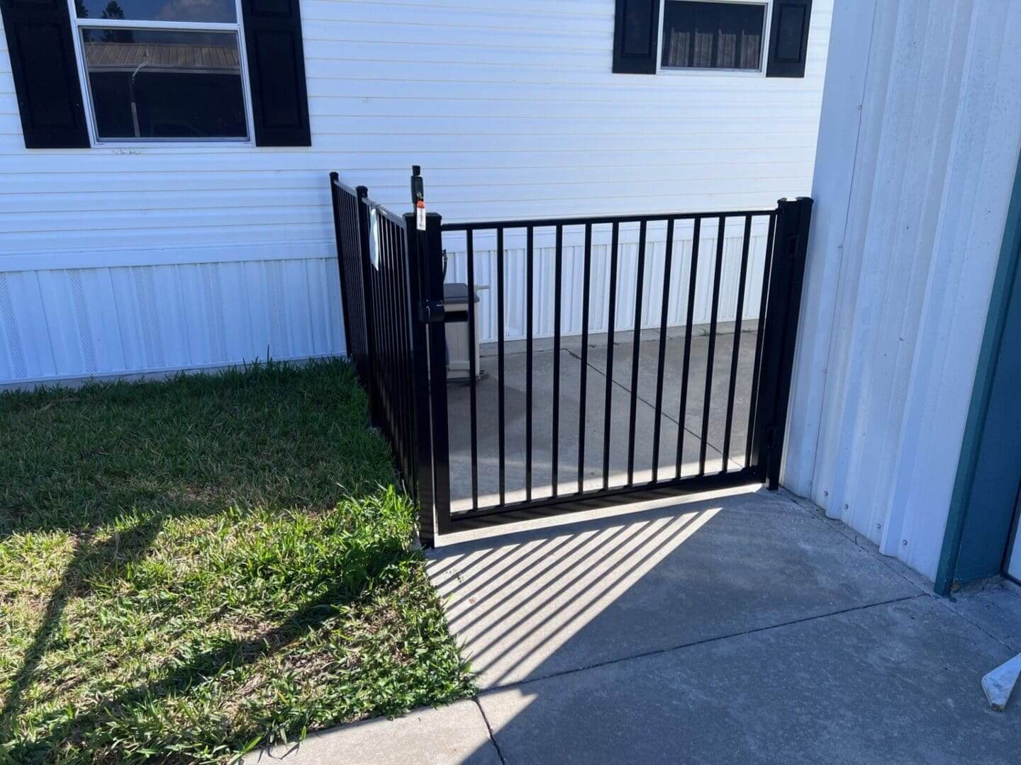 Black metal gate on concrete patio.
