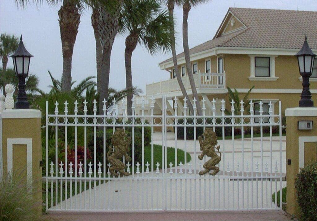 A gated driveway with trees in the background.