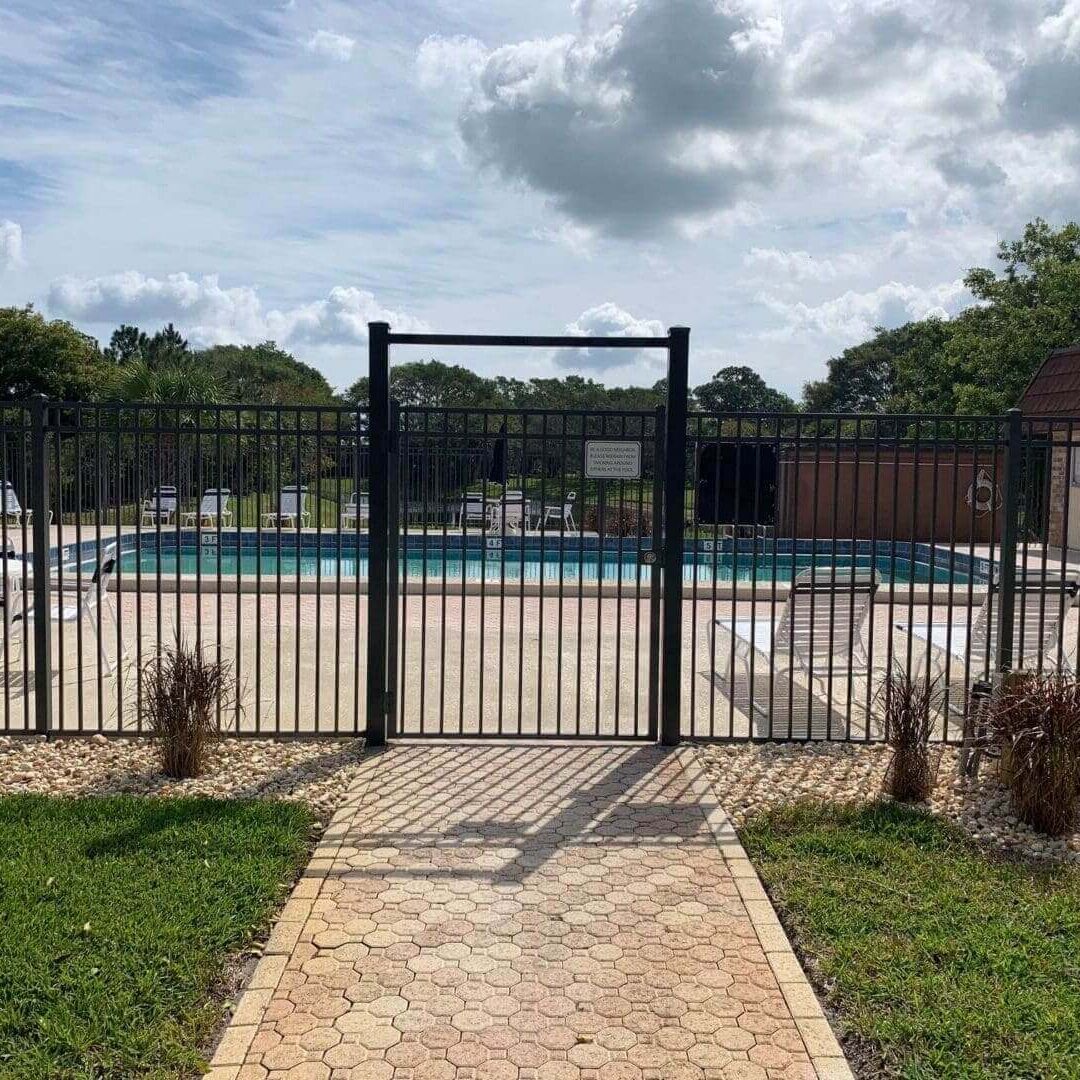 Paved path to fenced outdoor swimming pool