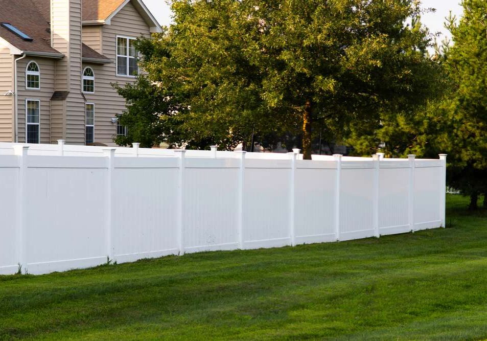 A white fence in the middle of a yard.